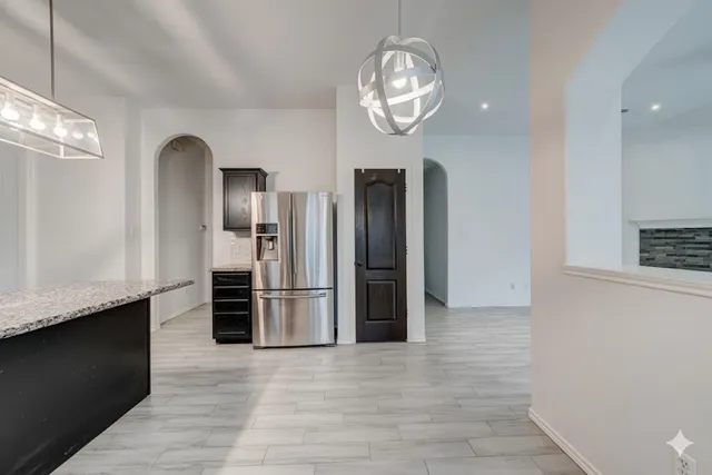 a kitchen with stainless steel appliances granite countertop a refrigerator and a stove top oven