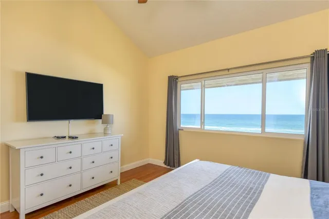 a bedroom with a bed and a flat tv screen on dresser