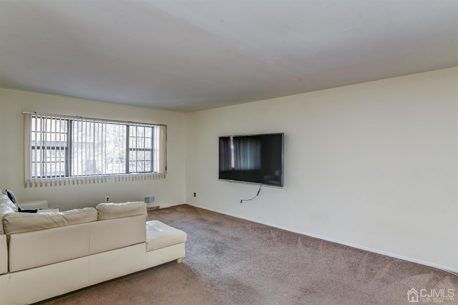 6902 Hana Road Edison, NJ 08817 - Photo 3 of 24 a living room with furniture and a flat screen tv