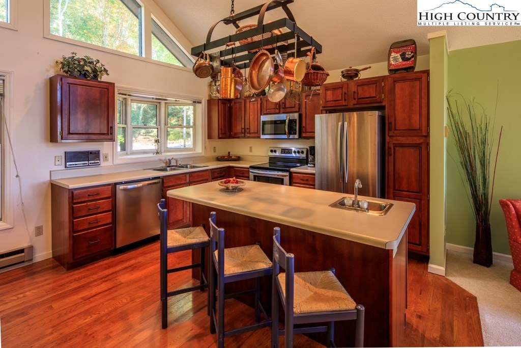 304 Lakeledge Road Beech Mountain, NC 28604 - Photo 14 of 42 a kitchen with stainless steel appliances a table chairs and a refrigerator