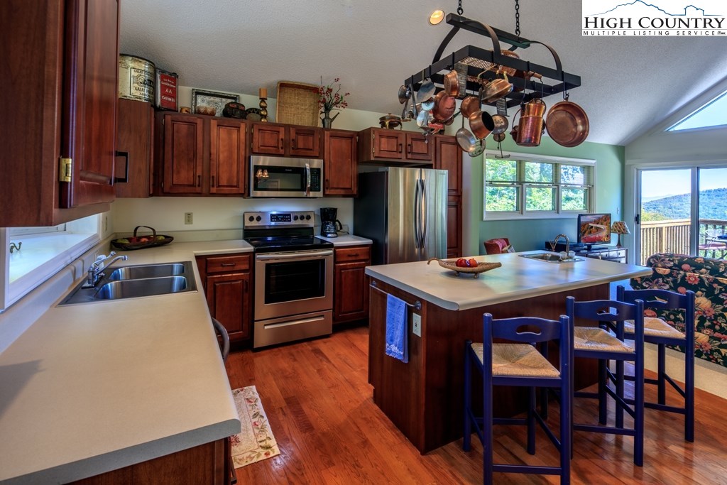 304 Lakeledge Road Beech Mountain, NC 28604 - Photo 16 of 42 a kitchen that has a table chairs and a stove