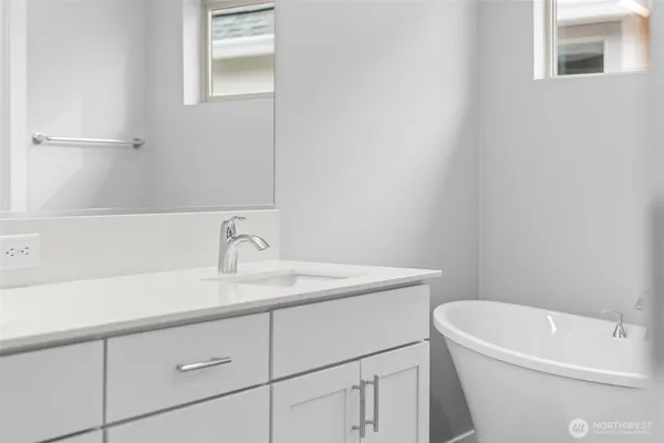 a bathroom with a bathtub and double sink