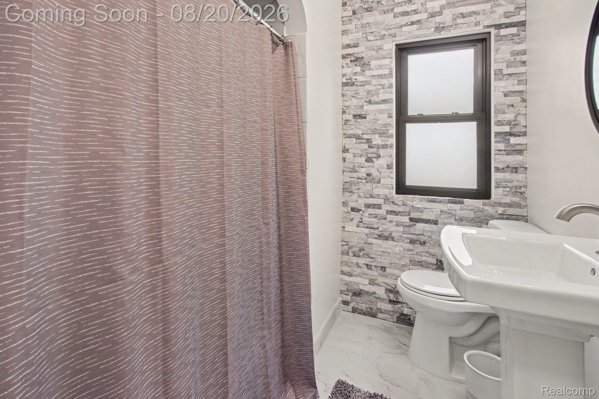 4098 Wakefield Road Berkley, MI 48072 - Photo 36 of 49 Pedestal sink with a brushed nickel faucet, wall-mounted mirror, and stone-look accent wall