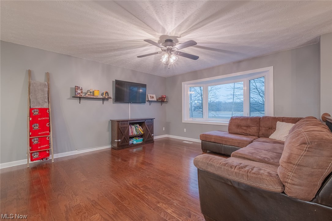 4179 Blake Road Seville, OH 44273 - Photo 7 of 29 Living room with engineered HW flooring and ceiling fan and bay window overlooking a rural view.