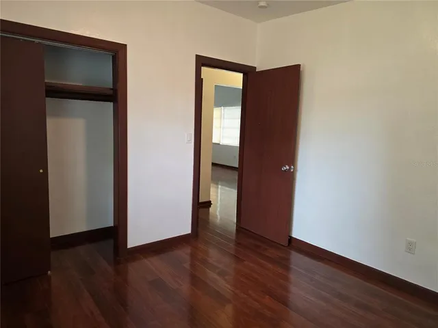an empty room with wooden floor and closet