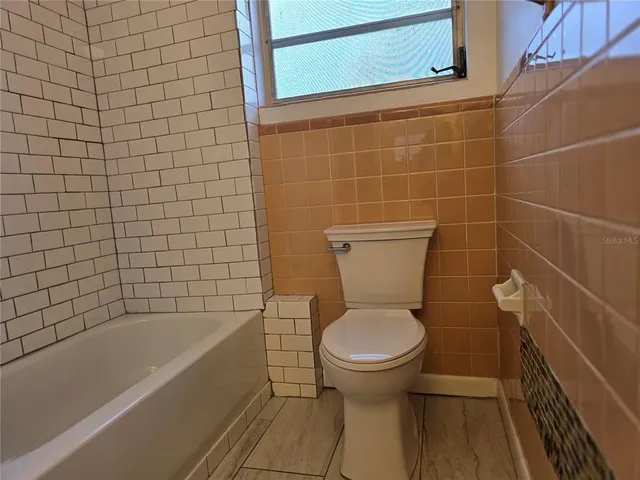 a bathroom with a toilet and a bathtub