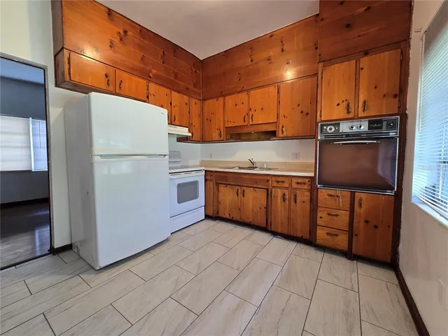 a kitchen with stainless steel appliances granite countertop a refrigerator a stove and a sink