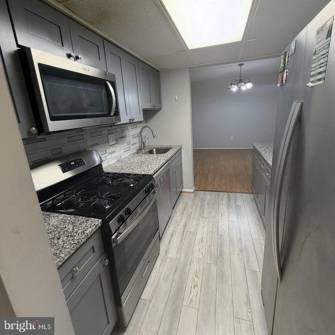 2628-00 Welsh Road, Unit 111 Philadelphia, PA 19152 - Photo 5 of 11 a kitchen with granite countertop a sink and steel stainless steel appliances