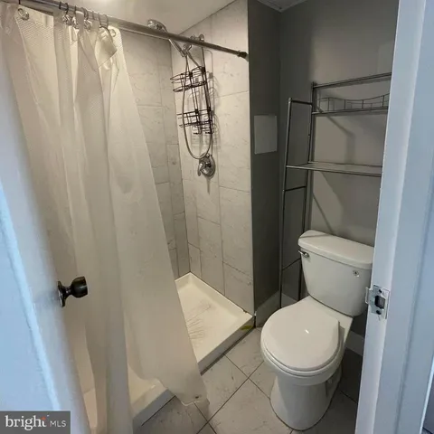 a white toilet sitting next to a shower