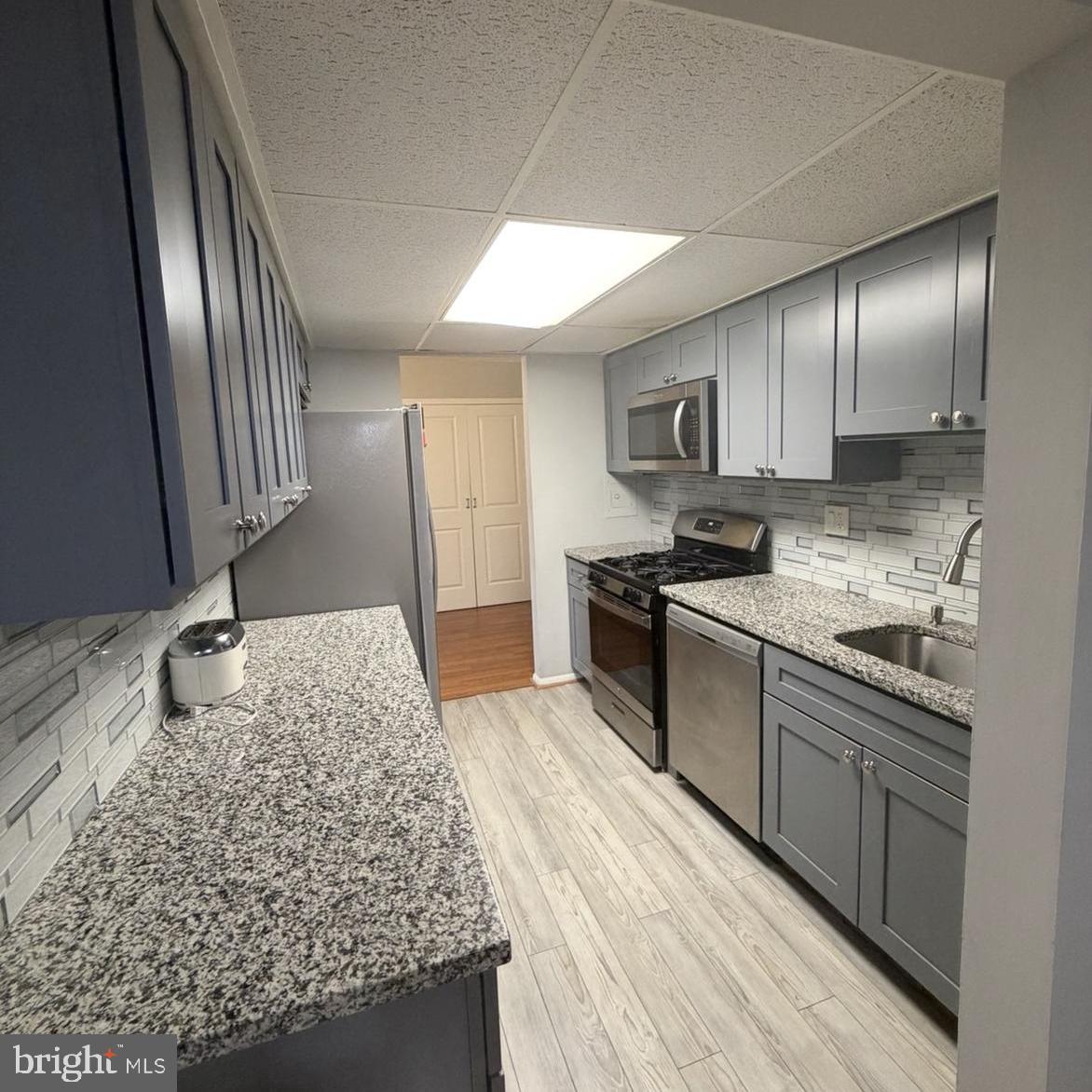2628-00 Welsh Road, Unit 111 Philadelphia, PA 19152 - Photo 5 of 11 a kitchen with stainless steel appliances granite countertop a sink stove and refrigerator