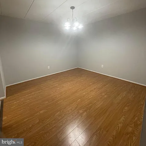 en empty room with wooden floor and windows