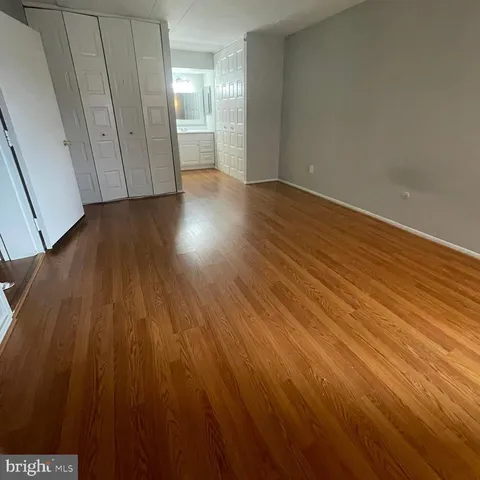 a view of an empty room with wooden floor