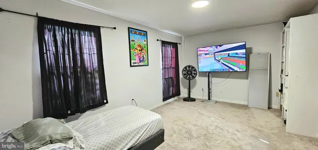 a bedroom with a bed and painting on the wall