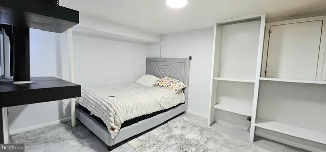 a bedroom with a bed and a flat tv screen on a dresser