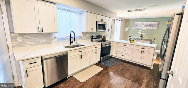 a kitchen with white cabinets and sink