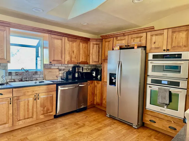 a kitchen with granite countertop a refrigerator and a sink