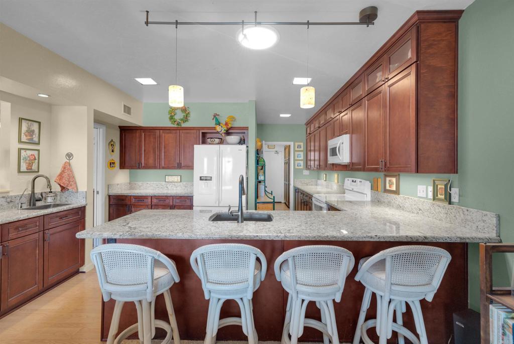 202 Pointing Rock Drive, Unit 6 Borrego Springs, CA 92004 - Photo 15 of 28 a kitchen with granite countertop a dining table chairs counter space and cabinets