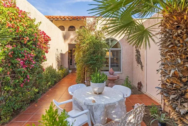 a view of a patio with table and chairs potted plants