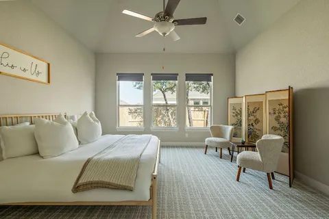 a spacious bedroom with a bed a couch and a large window