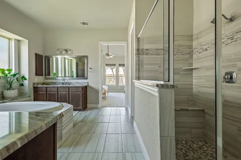 a spacious bathroom with a sink a bathtub a mirror a vanity and a shower