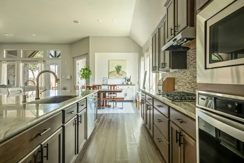 a kitchen with stainless steel appliances a sink stove and cabinets