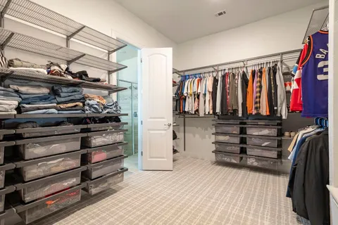 a view of walk in closet with clothes and shoes