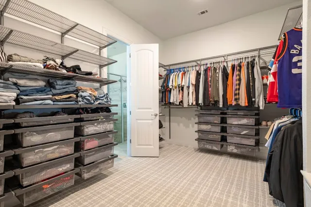 a view of walk in closet with clothes and shoes