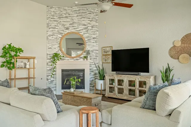 a living room with furniture a flat screen tv and a fireplace