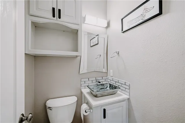 a bathroom with a sink toilet and a mirror