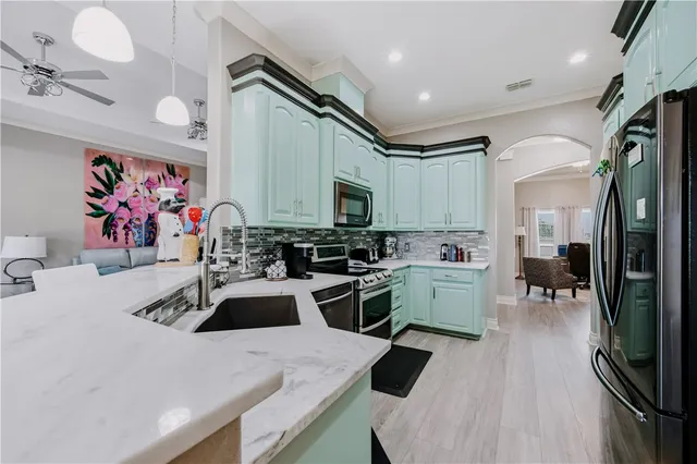 a kitchen with a sink a stove and chairs