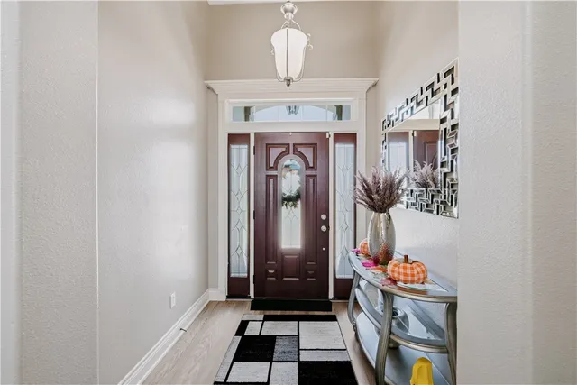 a hallway with front door wooden floor and livingroom