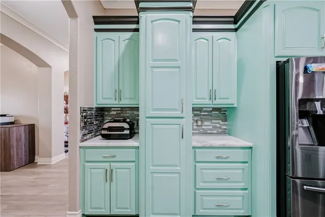 a kitchen with white cabinets and refrigerator