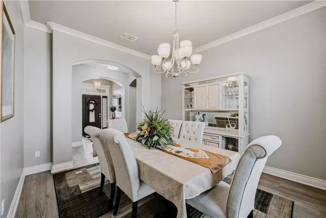 a view of a dining room with furniture and chandelier