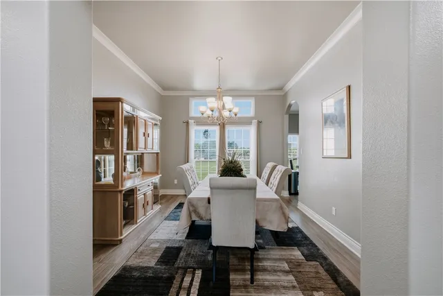 a dining room with furniture a chandelier and window