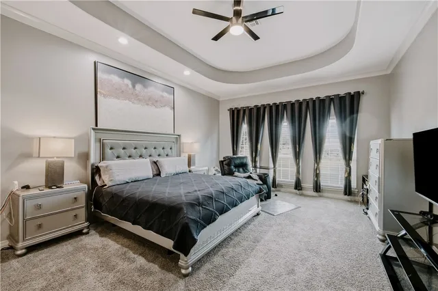 a bedroom with a bed tv and a chandelier