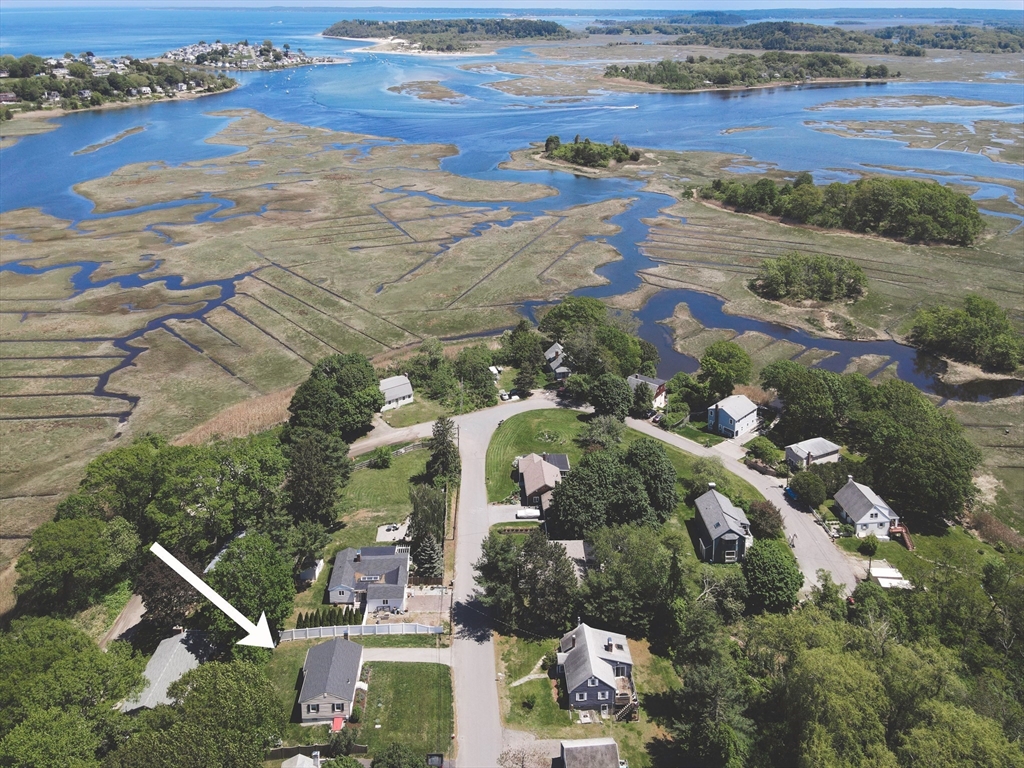 an aerial view of ocean and residential houses with outdoor space