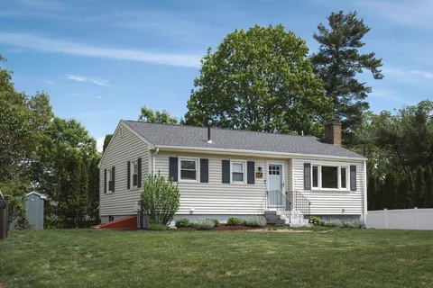 a front view of a house with a yard and tree s