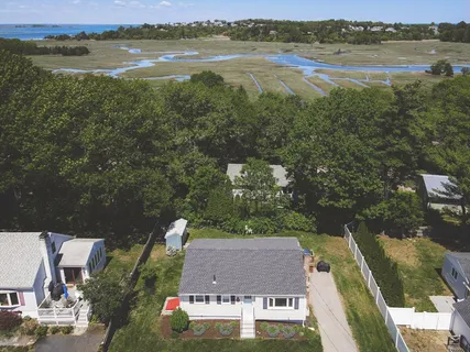 an aerial view of ocean and residential houses with outdoor space
