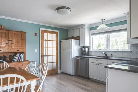 a kitchen with stainless steel appliances granite countertop a stove a sink dishwasher and a refrigerator with wooden floor