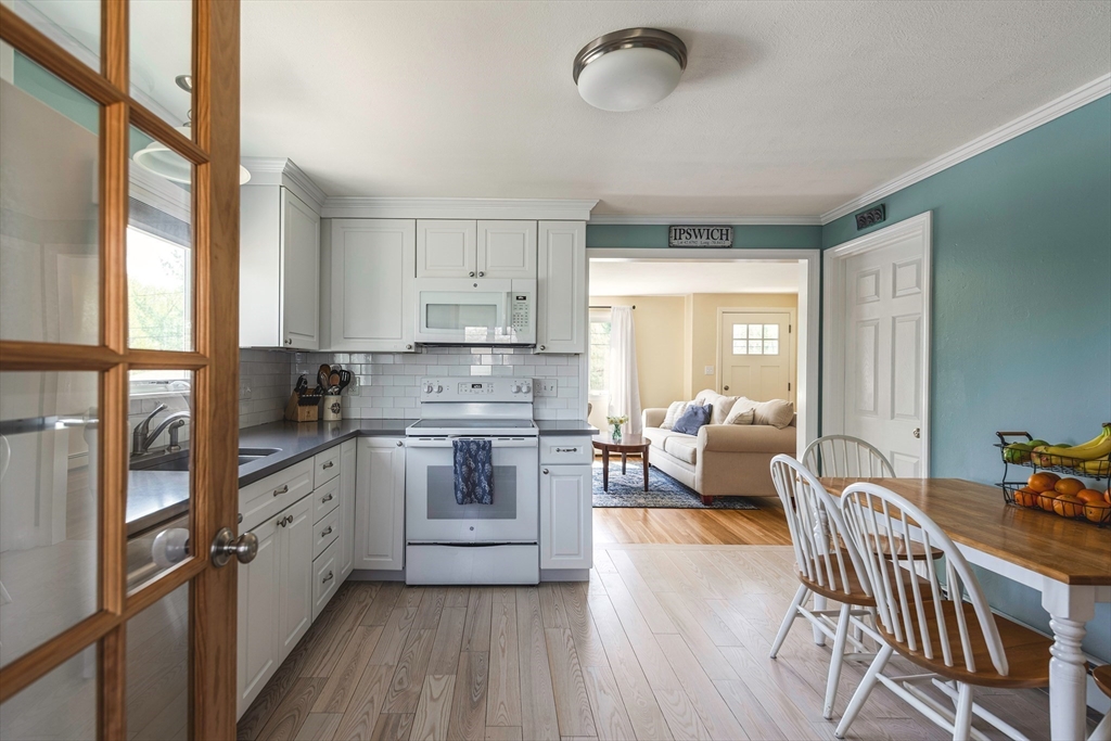 24 Island Park Road Ipswich, MA 01938 - Photo 5 of 25 a kitchen with stainless steel appliances granite countertop a stove a sink dishwasher and a refrigerator with wooden floor