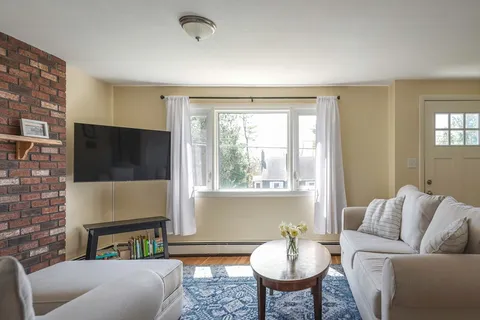 a living room with furniture a fireplace and a large window
