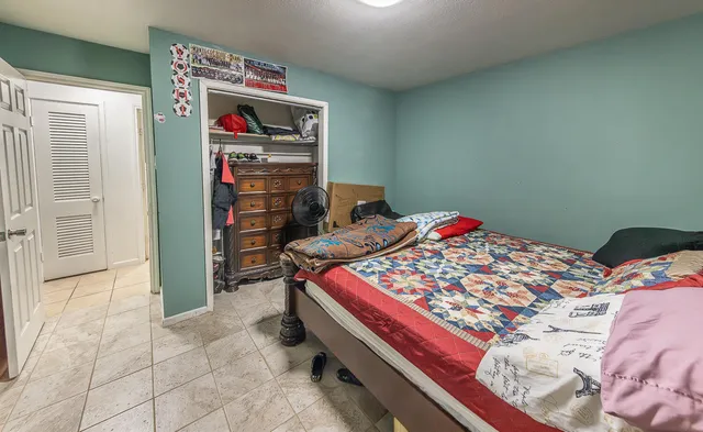 a bed sitting in a bedroom next to a window