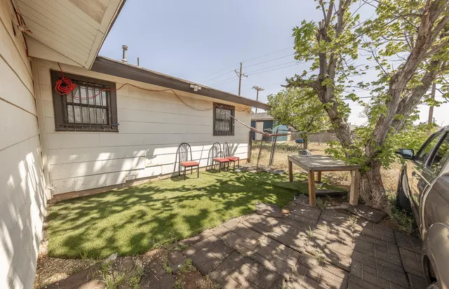 a backyard of a house with table and chairs
