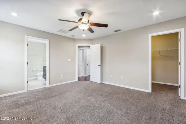 a view of an empty room with a chandelier fan
