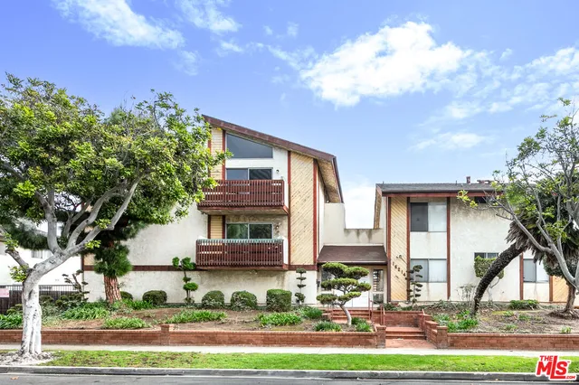a front view of a house with a yard and potted plants