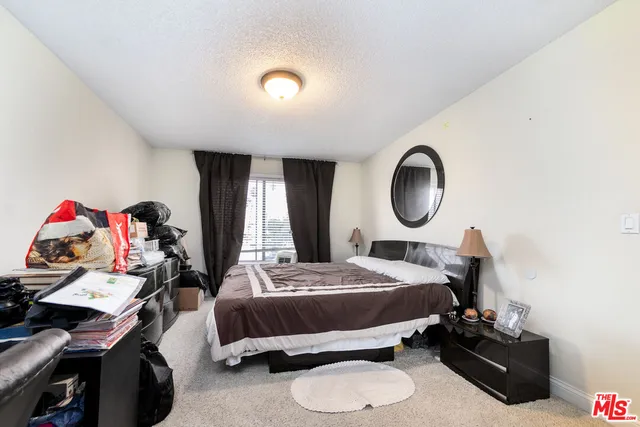 a bedroom with bed and a mirror