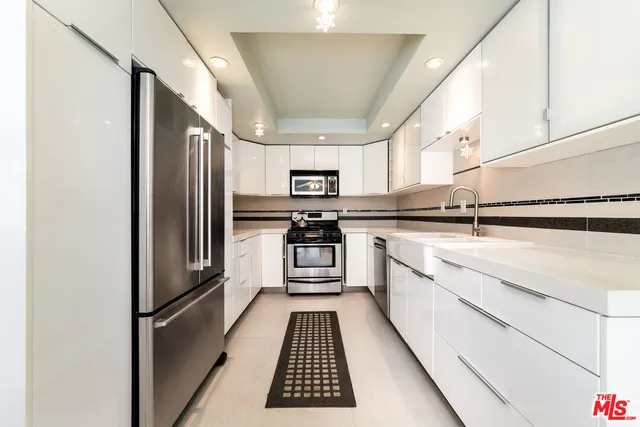 a kitchen with stainless steel appliances granite countertop a refrigerator and a sink