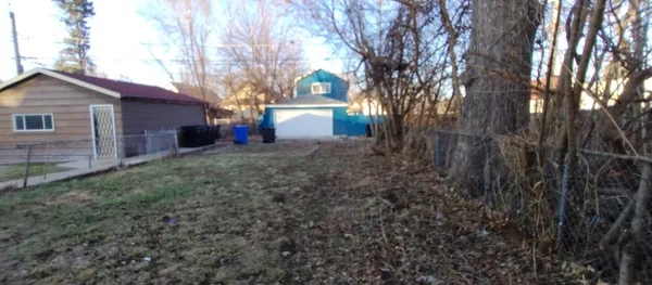 a view of a house with a yard and tree