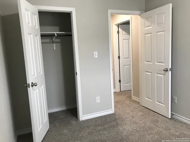 an empty room with closet and mirror