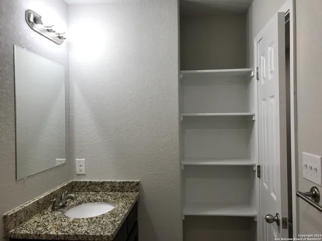 a bathroom with a granite countertop sink and a mirror